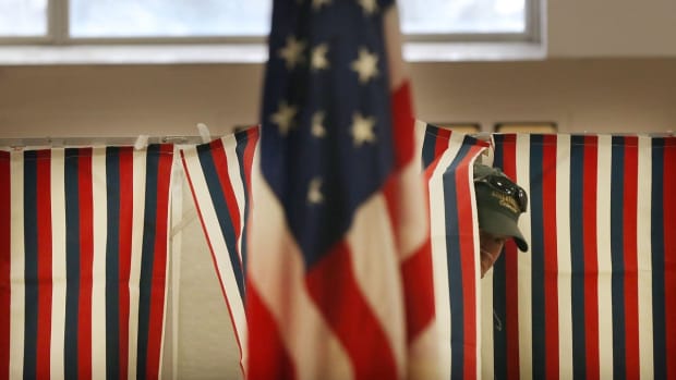 A man exits a voting booth inside of a middle school serving as a voting station.