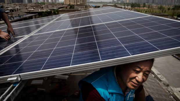 Chinese workers from the Wuhan Guangsheng Photovoltaic Company install solar panels on the roof of a building in Wuhan, China, on April 27th, 2017.