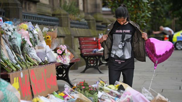 A 13-year-old girl who attended the Ariana Grande concert looks at floral tributes and messages in Manchester, England, on May 24th, 2017.