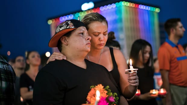 Nicole Edwards and her wife Kellie Edwards observe a moment of silence during a vigil outside the Dr. Phillips Center for the Performing Arts for the mass shooting victims at the Pulse nightclub June 13, 2016 in Orlando, Florida.