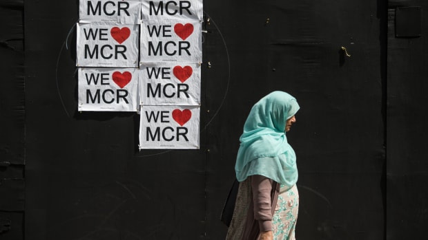 A woman walks past a poster displaying a message of defiance after the terror attack of May 22nd in Manchester, England, on May 31st, 2017.