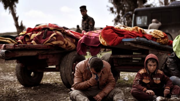 Relatives mourn as bodies of Iraqi residents of west Mosul killed in an airstrike are placed and covered with blankets on carts on March 17th, 2017.