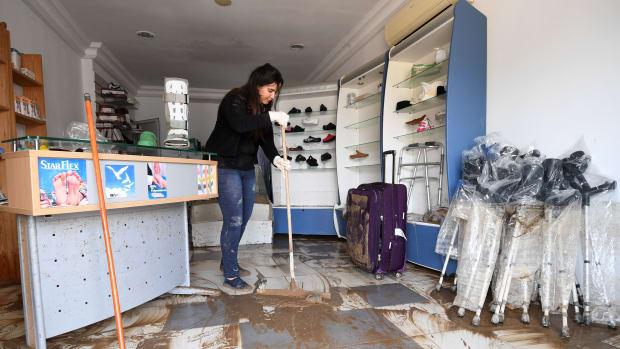 A Tunisian woman cleans her orthopedic shop in Manouba on June 6th, 2017, following a storm the previous night.