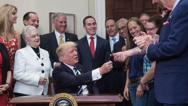 President Donald Trump hands over the pen he used to sign an executive order on the Apprenticeship and Workforce of Tomorrow initiatives on June 15th, 2017.