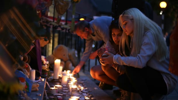 People light candles as they observe a vigil outside Notting Hill Methodist Church following the blaze at Grenfell Tower, a residential tower block in west London on June 15th, 2017.