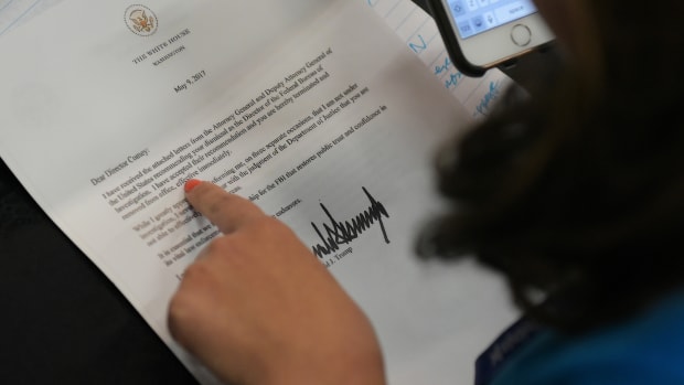A journalist looks at a copy of the termination letter to Federal Bureau of Investigation Director James Comey from President Donald Trump.