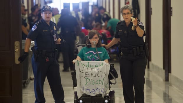 Police arrest a woman protesting against the Senate Republicans' draft health-care bill outside the Capitol Hill office of Senate Majority Leader Mitch McConnell on June 22nd, 2017.