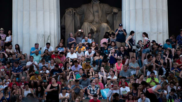 People wait on the Lincoln Memorial for fireworks to celebrate Independence Day on July 4th, 2017, in Washington, D.C.