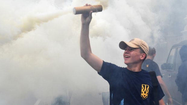 An activist holds up a flare during a protest in front of Ukrainian Parliament in Kiev on July 11th, 2017, demanding the removal of immunity for deputies. The parliament of Ukraine is debating the submission by the general prosecutor's office on the removal of parliamentary immunity from five parliamentarians suspected of corruption.