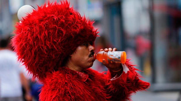 A man dressed as Elmo drinks to keep hydrated at Times Square during a sunny day as hot temperatures continue in New York on July 21st, 2017.