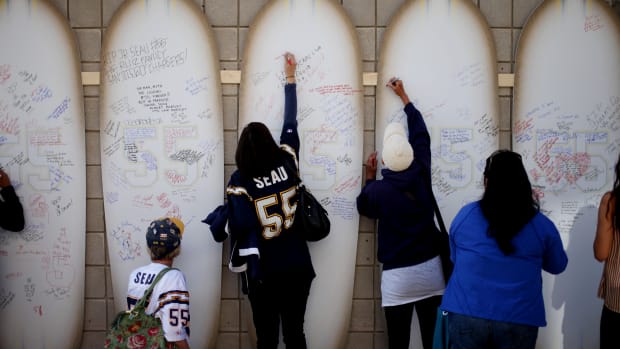 Friends, family members, and supporters sign surfboards as they pay tribute to former NFL star Junior Seau during a public memorial at Qualcomm Stadium on May 11th, 2012, in San Diego, California.