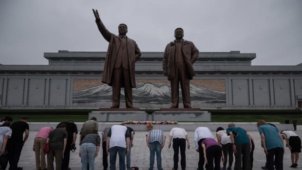 A group of tourists bow before statues of late North Korean leaders Kim Il-Sung (left) and Kim Jong-Il in Pyongyang on July 23rd, 2017.