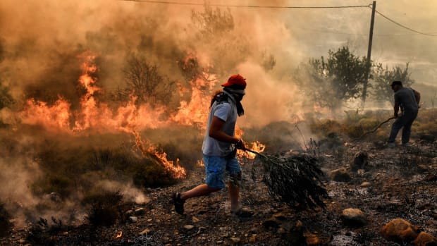 A man runs away from flames as fire burns the land, east of the Greek capital of Athens on August 15th, 2017. The army was called in to assist firefighters around Kalamos, 30 miles east of Athens, where a fire has been burning since August 13th. In all, 146 fires have broken out across Greece since then, according to authorities.