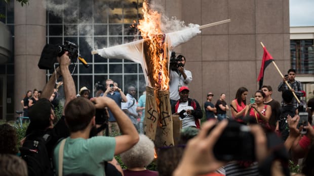 An effigy of U.S. President Donald Trump, dressed in khakis and a white shirt covered in swastikas, is set ablaze during a protest in Minneapolis, Minnesota, on August 14th, 2017.