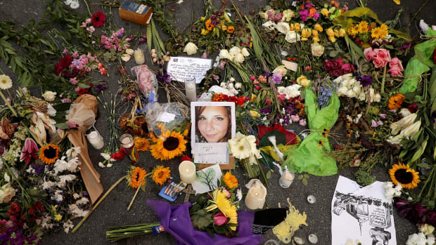 Flowers, candles, and chalk-written messages surround a photograph of Heather Heyer on the spot where she was killed and 19 others injured when a car slammed into a crowd of people protesting against a white supremacist rally on August 16th, 2017, in Charlottesville, Virginia.