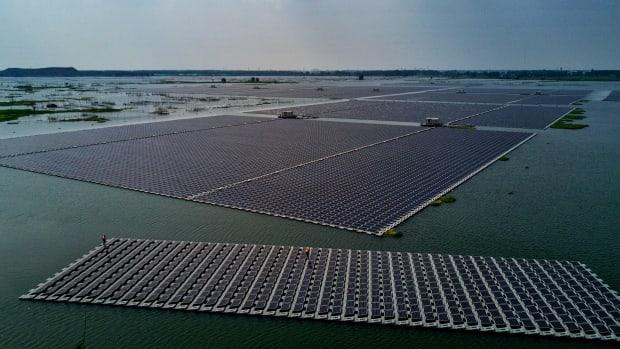 A boat tows a group of solar panels before they are connected to a large floating solar farm project on June 14th, 2017, in Huainan, Anhui province, China.