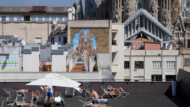 Tourists sunbathe on the terrace of an hotel with the Sagrada Familia in the background in Barcelona, Spain, on September 5th, 2017.