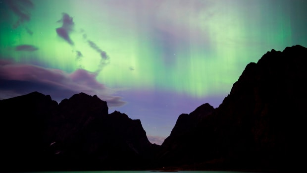 Northern lights (aurora borealis) illuminate the sky over Reinfjorden in Reine, on Lofoten Islands, Arctic Circle, on September 8th, 2017.