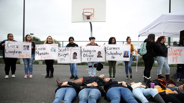 James Logan High School students hold signs honoring students killed at Marjory Stoneman Douglas High School as they observe a moment of silence during a walk out demonstration in Union City, California.