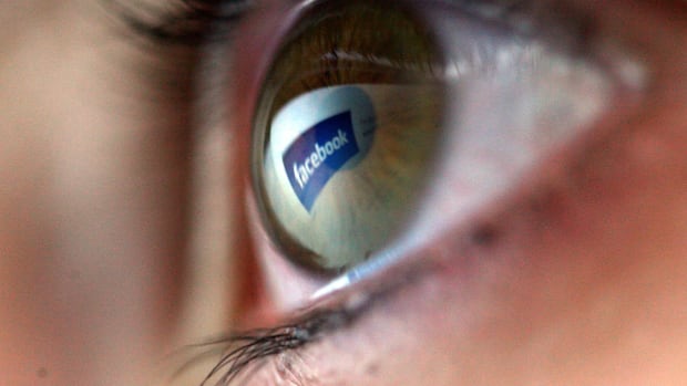 In this photo illustration the Facebook logo is reflected in the eye of a girl.