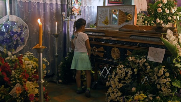 A girl grieves during the funeral of priest Walter Osmir Vásquez Jiménez, who was murdered by alleged gang members of the MS, in Lolotique, El Salvador, on April 1st, 2018.