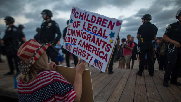 A demonstrator holds a sign during an America First rally on August 20th, 2017, in Laguna Beach, California.