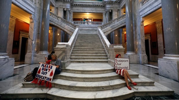Kentucky public school teachers sit outside the House chamber as they rally for a "day of action" at the Kentucky State Capitol to try to pressure legislators to override Kentucky Governor Matt Bevin's recent veto of the state's tax and budget bills on April 13th, 2018, in Frankfort, Kentucky.
