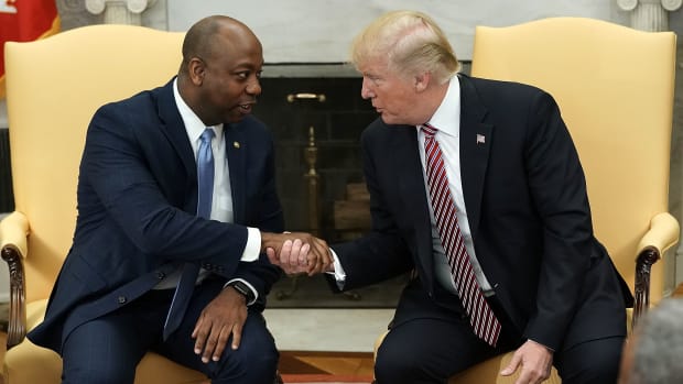 President Donald Trump shakes hands with Senator Tim Scott (R-South Carolina) during a working session regarding the Opportunity Zones provided by tax reform in the Oval Office of the White House on February 14th, 2018, in Washington, D.C.