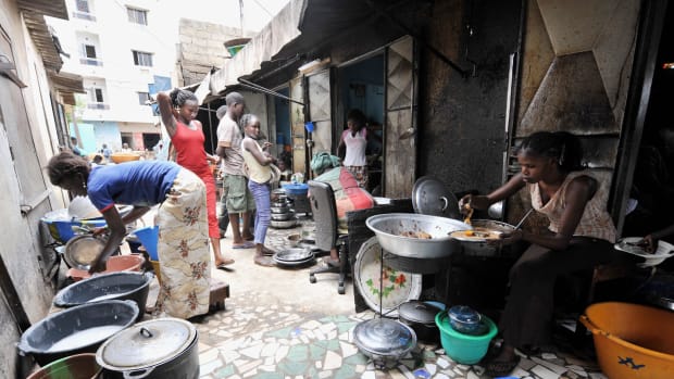 A woman prepares rice and fish at her street restaurant in Dakar, Senegal.