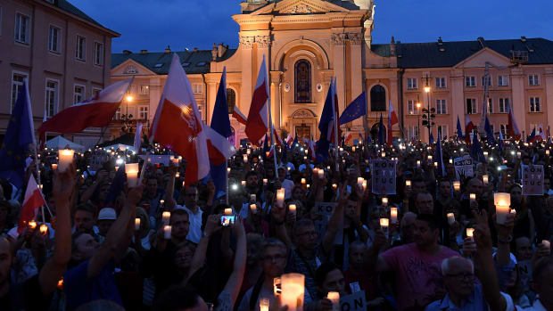 People hold candles and Polish national flags as they take part in a demonstration in front of the Polish Supreme Court on July 23rd, 2017, in Warsaw, Poland.