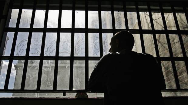 An inmate looks out of the window of the Young Offenders Institution in Norwich, England.