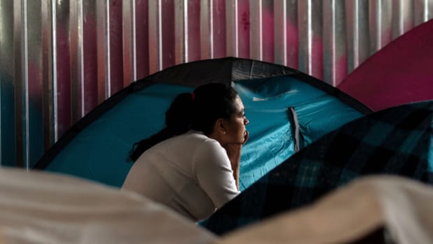 A migrant woman rests at her tent at Juventud 2000 migrant shelter in Tijuana on June 20th, 2018.