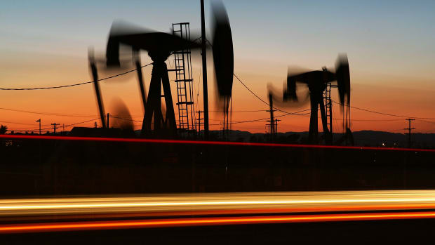 Car lights streak past an oil rig in Culver City, California.