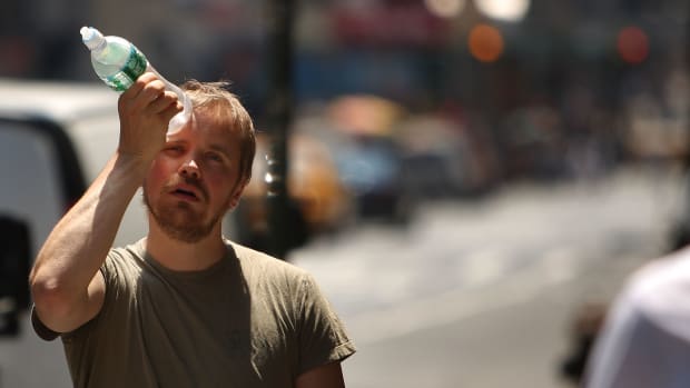 A man tries to cool himself with a bottle of water during a heat wave on June 9th, 2008, in New York City.