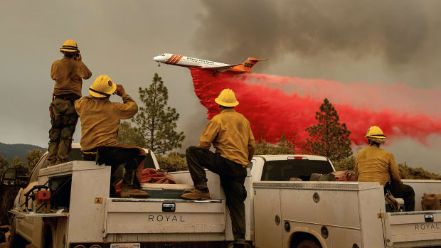 Firefighters watch as an air tanker drops fire retardant over the Ferguson Fire in the Stanislaus National Forest, near Yosemite National Park, on July 21st, 2018.