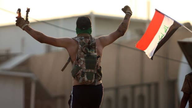 An Iraqi protester waves fire bombs during a protest outside the regional government headquarters in Basra on September 5th, 2018.