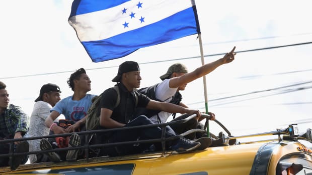 Migrants carry the flag of Honduras while on a caravan of immigrants en route to the Mexican border on October 18th, 2018, in Guatemala City, Guatemala. The caravan of thousands of Central Americans, most from Honduras, hopes to eventually reach the United States. U.S. President Donald Trump has threatened to cancel the recent trade deal with Mexico and withhold aid to Central American countries if the caravan isn't stopped before reaching the U.S.