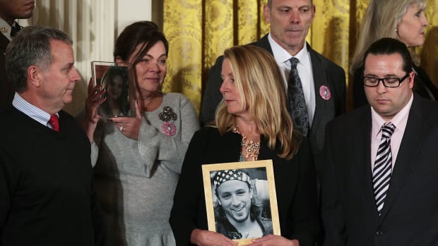 Families members hold pictures of the loved ones they lost to the opioid crisis during the event at which Trump declared the crisis a public-health emergency on October 26, 2017, in the East Room of the White House in Washington, D.C.