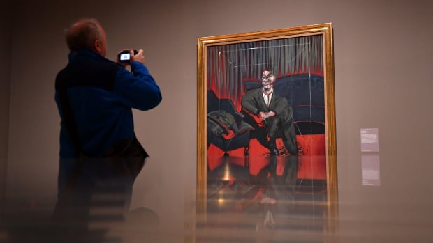 A man takes a photograph of Seated Figure, 1961, an oil painting by Irish-born British artist Francis Bacon, as part of the Queer British Art 1861-1967 exhibition at the Tate Britain in London on April 3rd, 2017.