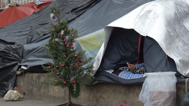 A Venezuelan migrant rests next to a Christmas tree at an improvised camp near a bus terminal in Bogota, Colombia, on November 9th, 2018.
