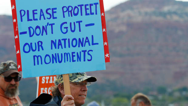 A man holds a sign on May 10th, 2017, protesting the shrinking of Bears Ears and Grand Staircase-Escalante National Monuments.