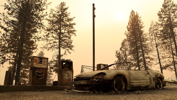 A burned out car sits next gas pumps at a gas station that was destroyed by the Camp Fire on November 11th, 2018, near Parkhill, California.