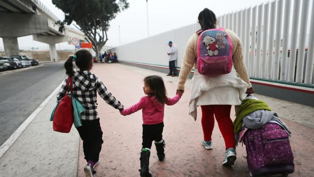 A migrant mother walks with her two daughters on their way to cross the port of entry into the U.S. for their asylum hearing on June 21st, 2018, in Tijuana, Mexico.