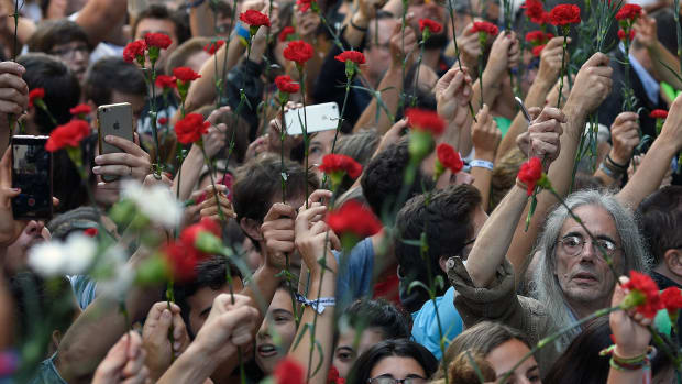 People hold flowers during a protest near the Economy headquarters of Catalonia's regional government in Barcelona on September 20th, 2017.