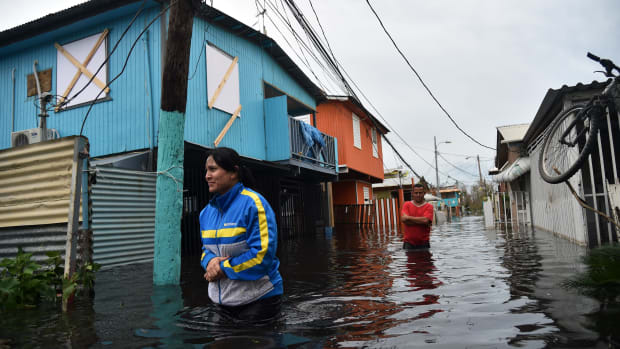 People walk across a flooded street in Juana Matos, Puerto Rico, on September 21st, 2017.