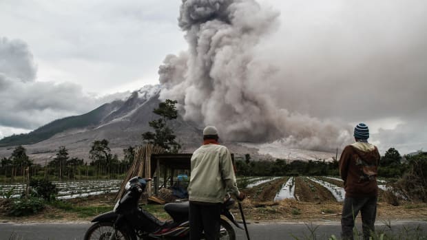 Indonesian villagers watch as Mount Sinabung volcano erupts in Karo, North Sumatra, on October 24th, 2017. Sinabung roared back to life in 2010 for the first time in 400 years and has remained highly active since.