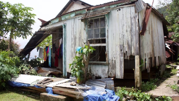 Flora's former house, which collapsed during Cyclone Winston. When it rains, the families hang clothes to dry under the remaining roof because there's no room in the tents.