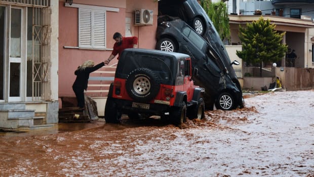 A man helps evacuate a woman from a flooded street in Mandra, Greece, on November 16th, 2017. A sudden overnight downpour flooded three towns near Athens, killing at least 15 people.