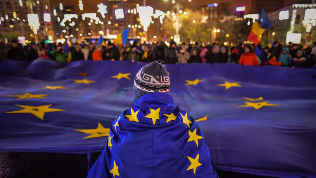Protesters hold a European Union flag during an anti-government and corruption protest at the Victoria square in front of the Romanian government headquarters, in Bucharest, on December 3rd, 2017.
