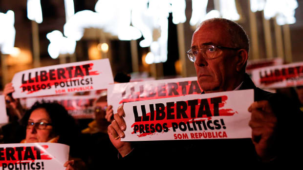 People hold banners reading Freedom for Political Prisoners in front of Barcelona's city hall on December 4th, 2017, during a demonstration demanding the release of jailed separatist leaders.